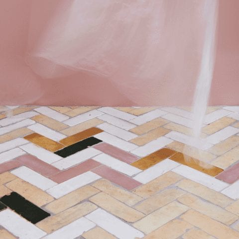 a whimsical floor with clé tile zellige bejmat tiles in natural, gold, and moroccan sea salt installed in a herringbone pattern